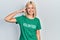 Beautiful blonde woman wearing volunteer t shirt smiling pointing to head with one finger, great idea or thought, good memory