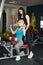 Beautiful blonde woman workout in fitness gim with her coach doing pull down exercises
