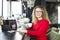 Beautiful blonde young woman drinking cappuccino coffee in a hipster bar and smiling. Curly haired female blogger, smiling, surfin