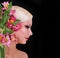 Beautiful blonde young woman with pink irises flowers over black, fashion model