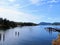 A beautiful blue bay with wooden jetties and a dock with boats surrounded by forested islands on Mayne Island, British Columbia