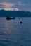 Beautiful blue early morning on calm sea with smooth waves, sky with fluffy clouds, blue mountains in haze, float boat, buoys.