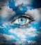 Beautiful blue eye against blue clouds - Spiritual concept