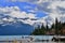 Beautiful blue Garibaldi Lake surrounded by trees and mountains covered with glacier.