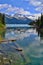 Beautiful blue Garibaldi Lake surrounded by trees and mountains covered with glacier.