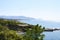 Beautiful blue lagoon with clear sea water and a pebble beach and rocks, deserted, with a view of the city in the distance.