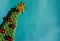 Beautiful blue minimalistic Christmas background. Handmade knitted Christmas tree with a gold tinsel star on the top of the head