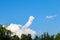 Beautiful blue sky with clouds in windy weather. The symbolic silhouette of a hand showing the middle finger