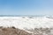 Beautiful blue sky on the horizon above a restless ocean or sea. View from the shore on the sea waves.