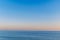 Beautiful blue sky over a slightly rippling blue sea in Ramsgate, Kent with the golden haze of a late afternoon sunset