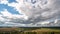 Beautiful blue sky with puffy white clouds over luscious green landscape, time lapse of clouds flying over flat terrain