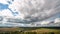 Beautiful blue sky with puffy white clouds over luscious green landscape, time lapse of clouds flying over flat terrain