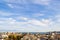 Beautiful blue sky with scenic fluffy clouds over seaside city on a sunny autumn day. Warm tranquil landscape with skyline