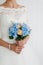 Beautiful blue and yellow fresh flowers wedding bouquet. Bride with wedding bouquet, closeup