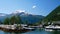 Beautiful boat marina harbor at Valldal, Norway on the calm waters of a fjord on a sunny day with snow on the peaks.