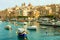 Beautiful boats in Valletta harbour with cityscape on the background