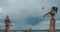 Beautiful bodies of young slender sportswomen playing at beach volleyball, closeup view, slow motion shot of jumping