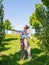 Beautiful boho style girl enjoying the freedom on a sunny day. Cheerful woman jumping on a green grass