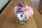 Beautiful bouquet of an assortment of annuals and perennial flowers on a hardwood table