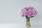 Beautiful bouquet of big pink peonies in transparent vase on white background. Lots of copy space. Greetings concept.