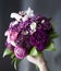 Beautiful bouquet of bride purple flowers on a dark background.