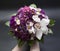 Beautiful bouquet of bride purple flowers on a dark background.