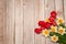 A beautiful bouquet of bright spring red tulips and yellow daffodils on a wooden background.