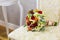 Beautiful bouquet of colorful flowers and green roses lying on a chair close-up