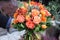 Beautiful bouquet in coral orange colors of roses, tulips, Jatropha multifida, Carthamus tinctorius and other plants in the male