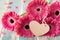 Beautiful bouquet from gerbera daisy flowers with greeting note in shape of heart for valentines, womans or mother day.