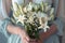 Beautiful bouquet of lilies held delicately in womans hands