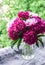 Beautiful bouquet of peonies on the window overlooking the garden - a cozy home still life. Natural beauty concept