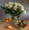 Beautiful bouquet of roses in a crystal jug and a pear with tangerines.