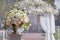 Beautiful bouquet of roses in a vase on a background of a wedding arch. Beautiful set up for the wedding ceremony.