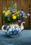 A beautiful bouquet of wildflowers in a large teapot used as a v