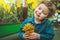 Beautiful boy playing with plant succulents in the retail store. Gardening In Greenhouse