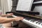 Beautiful Brazilian pianist woman touching piano keys, playing upright piano