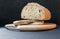 Beautiful bread made from rye and wheat flour on a wooden board on a black background. Sliced slices and half bread.