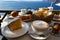 Beautiful breakfast with Aegean sea view and morning sunlight including cappuccino cup, cake, baguette, croissant, boiled egg