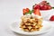 Beautiful breakfast. Belgian Viennese waffles decorated with strawberries, tea on a light background