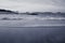 Beautiful breaking waves on sandy beach on atlantic ocean in black and white, hendaye, basque country,