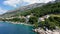 Beautiful Brela on Makarska riviera, Croatia. Adriatic Sea with amazing turquoise clean water and white sand. Aerial view of Brela