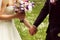 Beautiful bridal couple having fun in the park on their wedding day flower bouquet