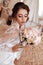 Beautiful bride with blond hair in elegant lace robe having morning preparation in wedding day