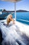 Beautiful bride blonde female model in amazing wedding dress poses on the island of Santorini in Greece and beyond