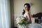 Beautiful bride with a bouquet of flowers in the hotel room