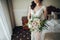 Beautiful bride with a bouquet of flowers in the hotel room