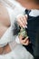 A beautiful bride corrects the groom`s boutonniere