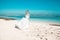 Beautiful bride dancing on the beach behind blue sky and sea