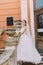 Beautiful bride in elegant white dress with long tail posing stairs romantic vintage building near baluster